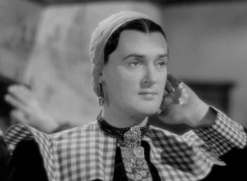 Movie still from “One of Our Aircraft Is Missing” (1942), directed by Emeric Pressburger – An old photo of a woman with a turban on a cell phone; Close Up shot, Low angle