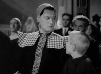 Movie still from “One of Our Aircraft Is Missing” (1942), directed by Emeric Pressburger – A man wearing a neck tie and a plaid tie; Medium shot, Over the shoulder angle