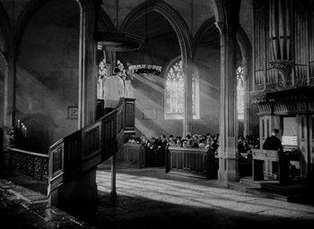 Movie still from “One of Our Aircraft Is Missing” (1942), directed by Emeric Pressburger – A black - and - white photo of people in a church; Extreme Wide shot, Low angle