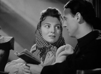 Movie still from “One of Our Aircraft Is Missing” (1942), directed by Emeric Pressburger – A man and a woman are holding a book; Close Up shot, Low angle