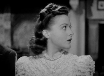 Movie still from “One of Our Aircraft Is Missing” (1942), directed by Emeric Pressburger – An old photo of a woman in a white dress looking to her left; Close Up shot, High angle