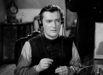 Movie still from “One of Our Aircraft Is Missing” (1942), directed by Emeric Pressburger – A black and white photo of a man wearing headphones; Close Up shot, High angle