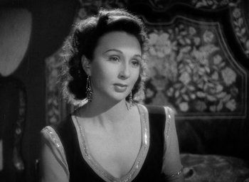 Movie still from “One of Our Aircraft Is Missing” (1942), directed by Emeric Pressburger – An old photo of a woman in a black dress; Close Up shot, High angle