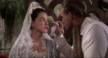 Movie still from “One-Eyed Jacks” (1961), directed by Marlon Brando – A man putting makeup on a woman's face; Close Up shot, Over the shoulder angle