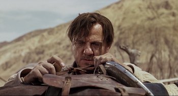 Movie still from “One-Eyed Jacks” (1961), directed by Marlon Brando – A man is fixing his horse's harness on a hill; Close Up shot, Low angle