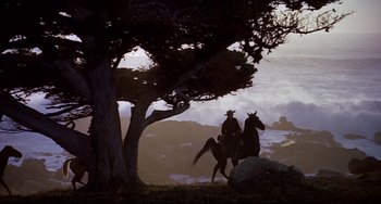Movie still from “One-Eyed Jacks” (1961), directed by Marlon Brando – Two people on horseback riding through a tree; Wide shot, Low angle