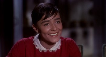 Movie still from “One-Eyed Jacks” (1961), directed by Marlon Brando – A young woman smiles brightly while wearing a red sweater; Close Up shot, High angle