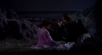 Movie still from “One-Eyed Jacks” (1961), directed by Marlon Brando – A man and a woman sitting on the beach at night; Wide shot, High angle