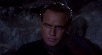 Movie still from “One-Eyed Jacks” (1961), directed by Marlon Brando – A person wearing a suit and tie; Close Up shot, Over the shoulder angle