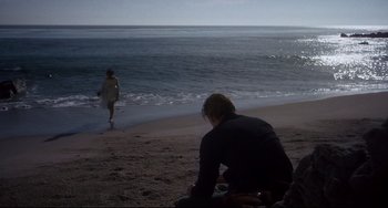 Movie still from “One-Eyed Jacks” (1961), directed by Marlon Brando – A man sitting on the beach looking at a woman walking on the beach; Wide shot, Over the shoulder angle