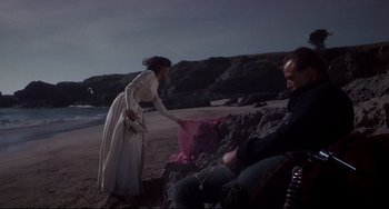 Movie still from “One-Eyed Jacks” (1961), directed by Marlon Brando – Two people sitting on the beach near the water; Wide shot, High angle