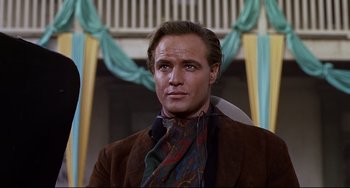 Movie still from “One-Eyed Jacks” (1961), directed by Marlon Brando – A person wearing a suit and tie; Close Up shot, Low angle