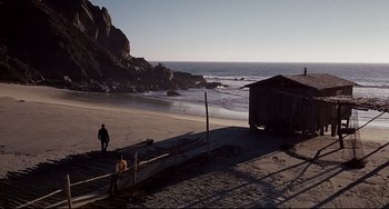 Movie still from “One-Eyed Jacks” (1961), directed by Marlon Brando – Two people standing on a beach near a shack; Extreme Wide shot, High angle