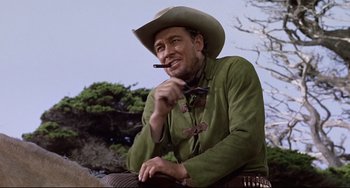 Movie still from “One-Eyed Jacks” (1961), directed by Marlon Brando – A man wearing a cowboy hat while holding a cigar; Medium shot, Low angle