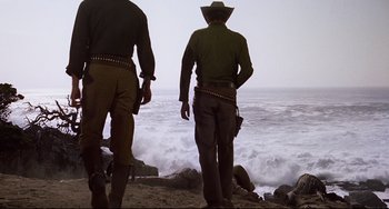 Movie still from “One-Eyed Jacks” (1961), directed by Marlon Brando – A couple of men standing on top of a sandy beach; Wide shot, Low angle