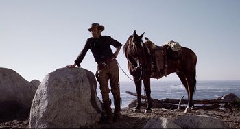 Movie still from “One-Eyed Jacks” (1961), directed by Marlon Brando – A man standing next to a horse on a beach; Medium shot, Low angle