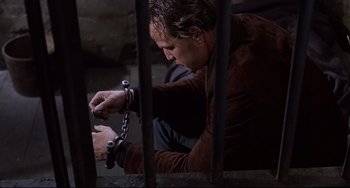 Movie still from “One-Eyed Jacks” (1961), directed by Marlon Brando – A man in brown shirt holding a metal handcuff; Close Up shot, Low angle