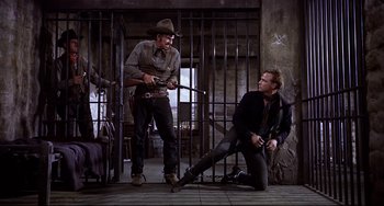 Movie still from “One-Eyed Jacks” (1961), directed by Marlon Brando – Two men are sitting on the ground in a jail cell; Wide shot, Low angle