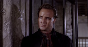 Movie still from “One-Eyed Jacks” (1961), directed by Marlon Brando – A person wearing a suit and tie; Close Up shot, Low angle