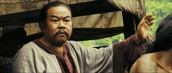 Movie still from “Ong Bak 2” (2008), directed by Tony Jaa – An older man with a beard and a mustache; Close Up shot, Low angle