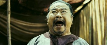 Movie still from “Ong Bak 2” (2008), directed by Tony Jaa – An older man with a surprised look on his face; Close Up shot, Low angle