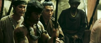Movie still from “Ong Bak 2” (2008), directed by Tony Jaa – A group of men standing next to each other; Medium shot, Over the shoulder angle