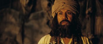 Movie still from “Ong Bak 2” (2008), directed by Tony Jaa – A man with long hair and a beard wearing a turban; Close Up shot, Low angle