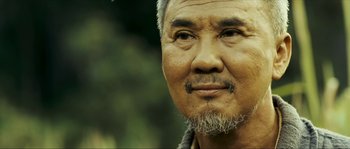 Movie still from “Ong Bak 2” (2008), directed by Tony Jaa – An older man with a beard and mustache; Close Up shot, Over the shoulder angle