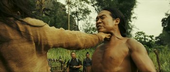 Movie still from “Ong Bak 2” (2008), directed by Tony Jaa – A man is holding a large animal in his hand; Medium shot, Over the shoulder angle
