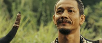 Movie still from “Ong Bak 2” (2008), directed by Tony Jaa – A person with a beard looking at the camera; Close Up shot, Low angle