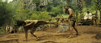 Movie still from “Ong Bak 2” (2008), directed by Tony Jaa – A man is kicking another man in the dirt; Wide shot, Low angle