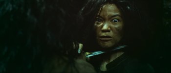Movie still from “Ong Bak 2” (2008), directed by Tony Jaa – A woman with a knife in her mouth; Close Up shot, Over the shoulder angle