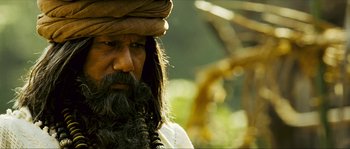 Movie still from “Ong Bak 2” (2008), directed by Tony Jaa – A man with long hair and a beard wearing a turban; Close Up shot, Low angle