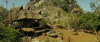 Movie still from “Ong Bak 2” (2008), directed by Tony Jaa – An old village with a hut and a mountain in the background; Extreme Wide shot, High angle