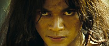 Movie still from “Ong Bak 2” (2008), directed by Tony Jaa – A person's face with yellow eyes; Close Up shot, Low angle