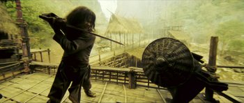 Movie still from “Ong Bak 2” (2008), directed by Tony Jaa – A man is holding a sword and a shield; Wide shot, Low angle