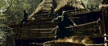 Movie still from “Ong Bak 2” (2008), directed by Tony Jaa – A group of men in black suits and masks on a wooden platform; Wide shot, Low angle