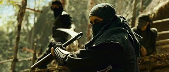 Movie still from “Ong Bak 2” (2008), directed by Tony Jaa – A man in a black ninja outfit holding an axe; Medium shot, Low angle