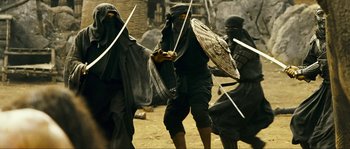 Movie still from “Ong Bak 2” (2008), directed by Tony Jaa – A group of people dressed up as ninjas with swords; Medium shot, Low angle