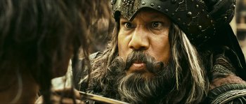 Movie still from “Ong Bak 2” (2008), directed by Tony Jaa – A person with a beard and mustache; Close Up shot, Low angle