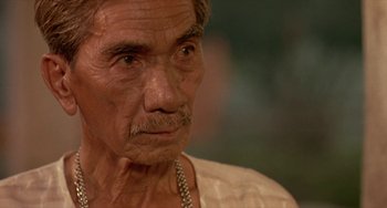 Movie still from “Ong-Bak: The Thai Warrior” (2003), directed by Prachya Pinkaew – An old man with a beard and a mustache; Close Up shot, High angle