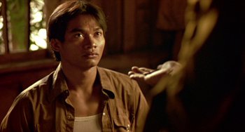 Movie still from “Ong-Bak: The Thai Warrior” (2003), directed by Prachya Pinkaew – A man standing in front of another man with his hand on his shoulder; Close Up shot, Over the shoulder angle