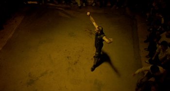 Movie still from “Ong-Bak: The Thai Warrior” (2003), directed by Prachya Pinkaew – A man in black shirt throwing a baseball; Wide shot, Overhead angle