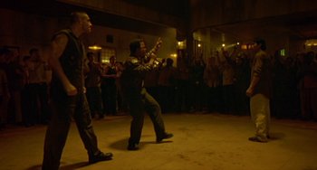 Movie still from “Ong-Bak: The Thai Warrior” (2003), directed by Prachya Pinkaew – Two men are dancing in front of an audience; Wide shot, High angle