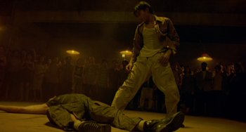 Movie still from “Ong-Bak: The Thai Warrior” (2003), directed by Prachya Pinkaew – A man standing over another man on the ground; Wide shot, Low angle