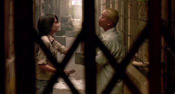 Movie still from “Ong-Bak: The Thai Warrior” (2003), directed by Prachya Pinkaew – A man and a woman standing next to each other; Medium shot, Over the shoulder angle