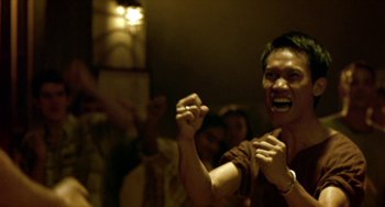Movie still from “Ong-Bak: The Thai Warrior” (2003), directed by Prachya Pinkaew – A man with his fists in the air; Close Up shot, Low angle