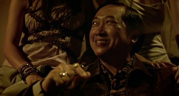 Movie still from “Ong-Bak: The Thai Warrior” (2003), directed by Prachya Pinkaew – An older asian man with a ring in his hand; Close Up shot, Low angle