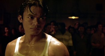 Movie still from “Ong-Bak: The Thai Warrior” (2003), directed by Prachya Pinkaew – A person wearing a tank top; Close Up shot, Low angle