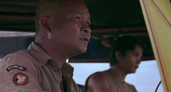 Movie still from “Ong-Bak: The Thai Warrior” (2003), directed by Prachya Pinkaew – A man with a shaved head is looking at the camera; Close Up shot, Low angle